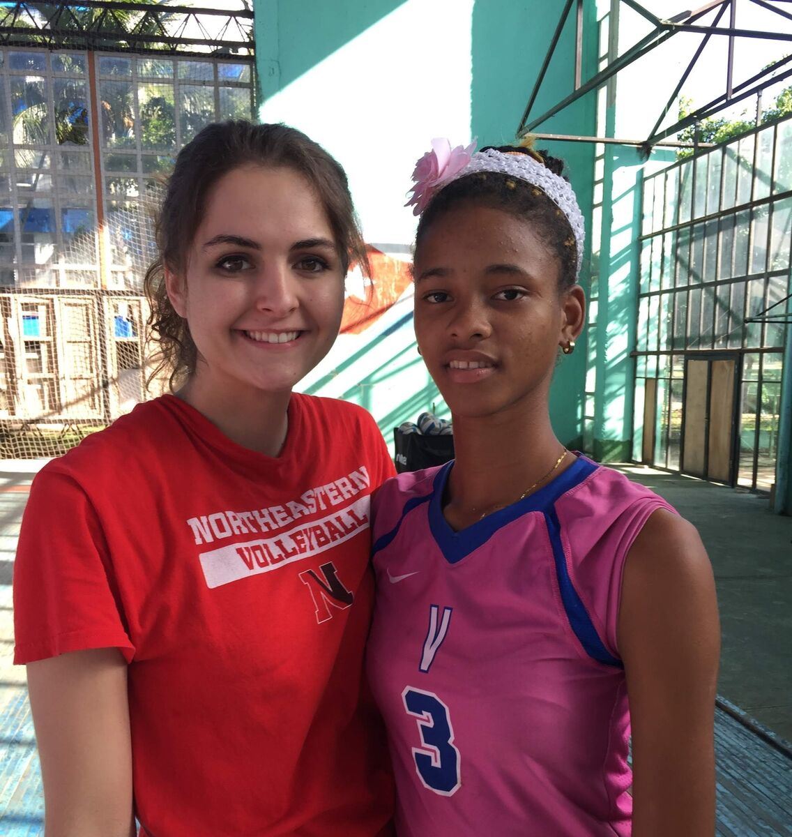 Two volleyball players standing together on a court after a clinic